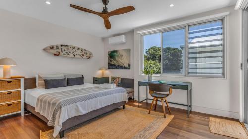 a bedroom with a bed and a desk and a window at Solara in Kingscliff