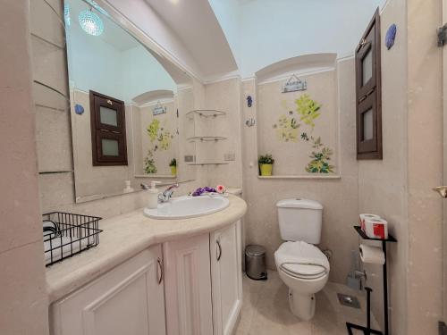 a bathroom with a sink and a toilet at Nayah Stays, Cozy lagoons terrace one ensuite Apt in Hurghada