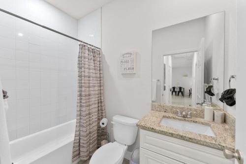 a white bathroom with a toilet and a sink at Busch Garden New House in Tampa