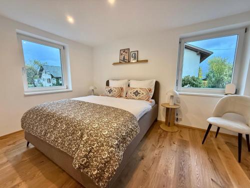 une chambre avec un lit et deux fenêtres dans l'établissement Haus Rautenweg, à Dornbirn