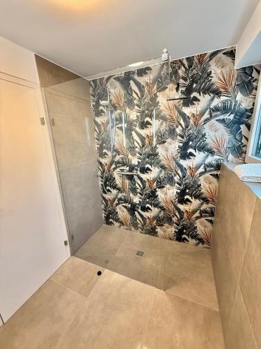 a bathroom with a tropical wallpaper on the wall at Haus Rautenweg in Dornbirn