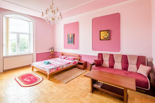 リヴィウにあるTwo Rooms Apart Prospekt Svobodyのピンクの壁のリビングルーム(ソファ、テーブル付)