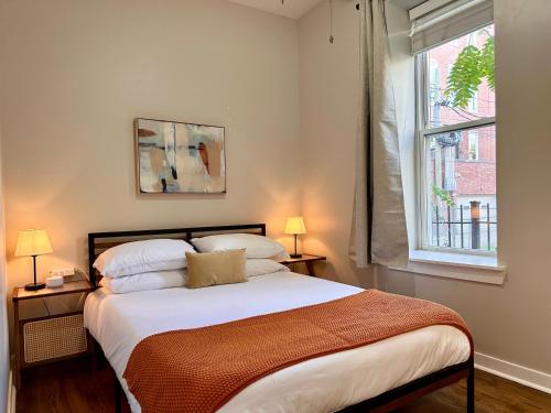 een slaapkamer met een bed met twee lampen en een raam bij Flexhome West Town 2BR Duplex Apt T2 in Chicago