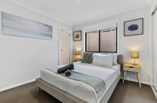 a bedroom with a large bed with two tables and two lamps at The Stayover Unit 2 - Your Wine Country Base in North Rothbury