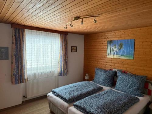 a bedroom with two beds and a large window at Landhaus am Waldrand in Oberndorf in Tirol