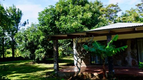 a house with a porch next to some trees at Tai Rapa Nui in Isla de Pascua