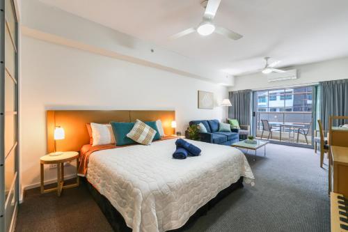 ein Schlafzimmer mit großem Bett und ein Wohnzimmer in der Unterkunft Darwin City Centre Apt 2 Bed, 2 Bath in Darwin