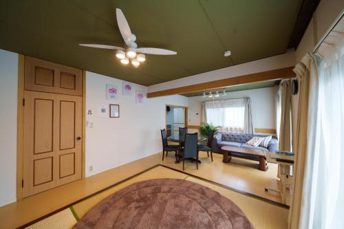 a living room with a ceiling fan and a couch at コルネット館山 in Tateyama