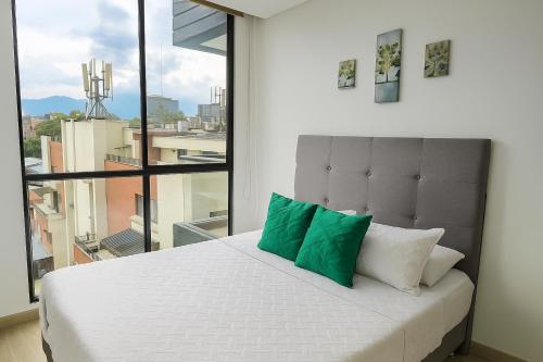 a bedroom with a bed with a large window at Moderno y amplio apartamento cerca a centros comerciales in Ibagué