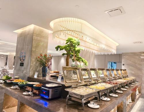 une ligne de buffet avec de nombreux types de nourriture différents dans l'établissement GUI YUAN ZHEN PIN HOTEL- Approximately 3 kilometers from the East Gate of Zhangjiajie National Forest Park - Free one-way pick-up or drop-off service for over 3 nights - English speaking customer service, à Zhangjiajie