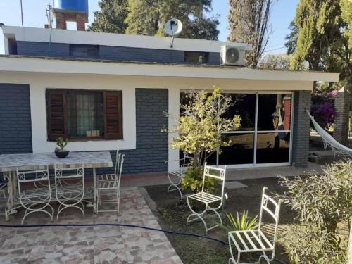 una casa con un patio con sillas y una mesa en La Chiquitita apart, 