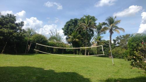 un filet de volley-ball dans un champ avec des palmiers dans l'établissement Chalés Paraíso Verde, à Itatiaia