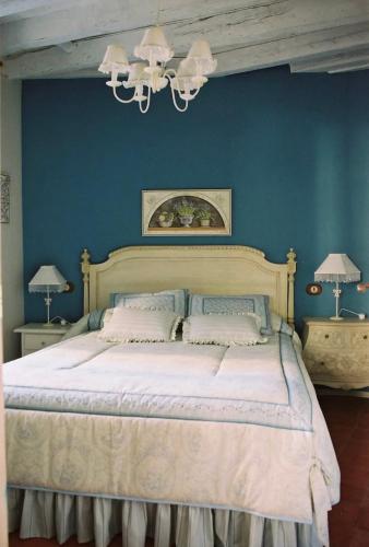 a bedroom with a large bed with blue walls at El Encanto in Miraflores de la Sierra