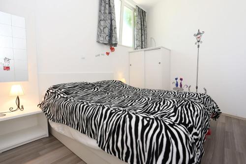 a zebra print bed in a white room at Apartment Ston 10226a in Mali Ston