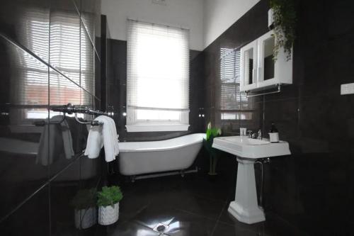 a bathroom with a tub and a sink and a window at Waterviews - Hidden Gem in CBD - Sleeps 10 in Wagga Wagga
