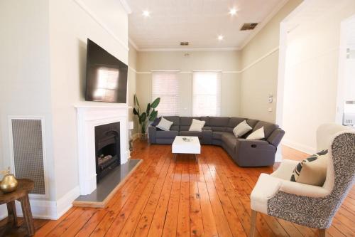 a living room with a couch and a fireplace at Waterviews - Hidden Gem in CBD - Sleeps 10 in Wagga Wagga