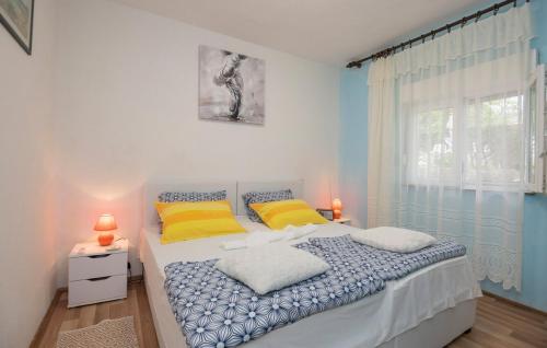 a bedroom with a bed with yellow pillows and a window at Family friendly house with a swimming pool Grab, Zagora - 15208 in Grab