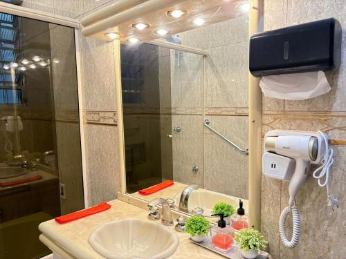 a bathroom with a sink and a mirror at 0003 - Pousada HG quarto home office single in Vila Gopoúva