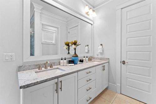 a white bathroom with a sink and a mirror at It's a Shore Thing in Inlet Beach