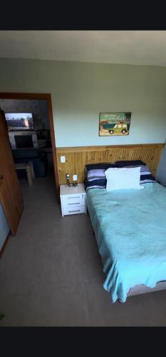 a bedroom with a large bed with blue sheets at Surfer paradise in Praia do Rosa