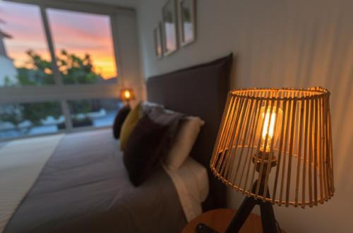 sala de estar con cama y lámpara en Santiago Centro I Eventos Movistar Arena, en Santiago