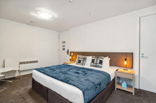 Un dormitorio con una cama grande y un escritorio. en Waterfront Queenstown Studio Peaceful Stay, en Frankton