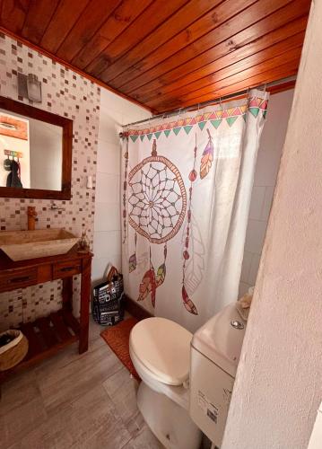 サン・クレメンテ・デル・トゥユにあるLa casitaのトイレとシャワーカーテン付きのバスルーム
