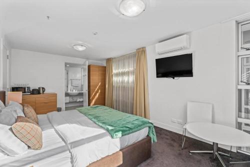 弗兰克顿Cosy & Comfortable Studio Marina 203a的一间带床、桌子和电视的卧室