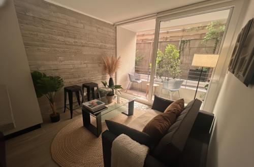 Una sala de estar con un sofá y una ventana grande. en Santiago Centro I Eventos Movistar Arena, en Santiago