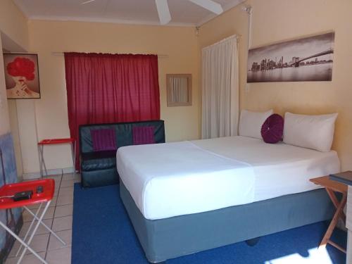 a hotel room with a bed and a chair at Yana House in Polokwane