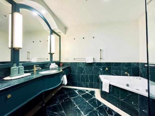 黄金海岸Boutique Ocean View Studio with King Bed & Spa的带浴缸和大镜子的浴室