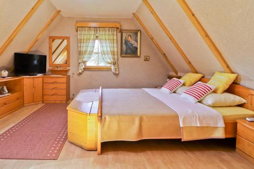 ein Schlafzimmer mit einem großen Bett und einem Fernseher in der Unterkunft Family friendly house with a swimming pool Gornja Voca, Zagorje - 11873 in Gornja Voća
