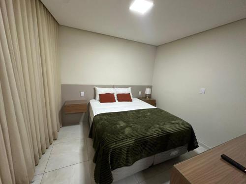 a bedroom with a large bed with red pillows at Magnificent coverage in São Roque