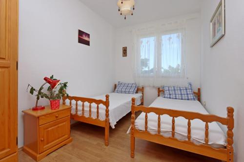 ein Schlafzimmer mit zwei Betten und einem Fenster in der Unterkunft Apartments with parking space Klenovica, Novi Vinodolski - 20174 in Klenovica