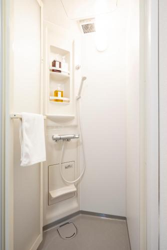 a white shower in a bathroom with a towel at 古民家宿 Hokusai 北斎 小樽運河5分 駅近 観光拠点 戸建貸切 in Otaru