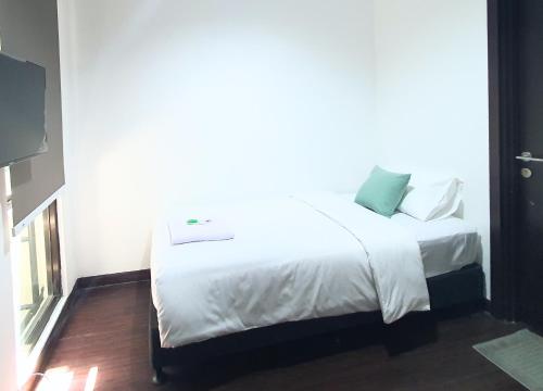 a bedroom with a white bed with a large window at The Breakout Room ICE BSD in Serpong