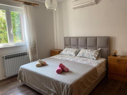 a bedroom with a bed with two pink shoes on it at Apartments with parking space Opric, Opatija - 7695 in Opric