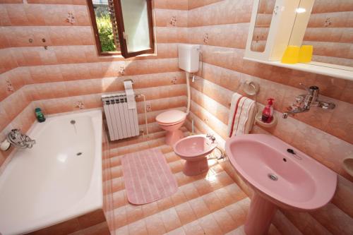 a bathroom with a pink sink and a tub and a toilet at Apartments with parking space Opric, Opatija - 7695 in Opric