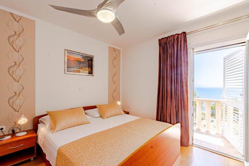 a bedroom with a bed and a large window at Seaside apartments with a swimming pool Prizba, Korcula - 10056 in Brnistrova
