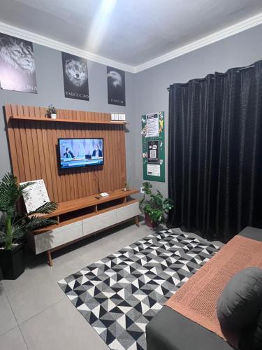 a living room with a flat screen tv on a wall at House Amorim 13 min Parque peão in Barretos