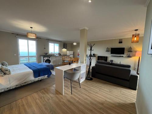 a bedroom with a bed and a living room at Villa Alta Vista in São Jorge
