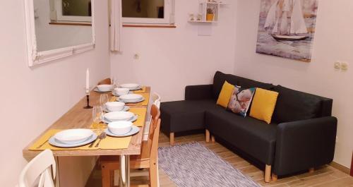 a living room with a table and a black couch at Apartments by the sea Ston, Peljesac - 10226 in Mali Ston