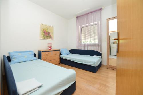 a small bedroom with two beds and a window at Apartments by the sea Vir - 24953 in Vir