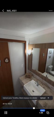 a bathroom with a sink and a large mirror at Surfer paradise in Praia do Rosa