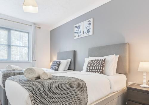 a white bedroom with two beds and a window at 2 Bedrooms - 3 Beds - Quiet Retreat - Parking in Stafford