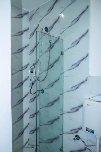 a shower in a bathroom with a glass wall at Lá Maison Jolly in Luanda