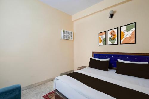 a bedroom with a bed with a blue headboard at Hotel O ONMT Inter College Kanpur Formerly Mangalam Palace in Panki