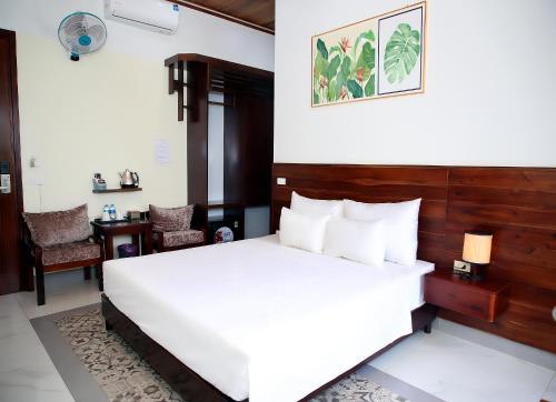 a bedroom with a large white bed and a desk at Daisy's Villa TamCoc in Vũ Lâm