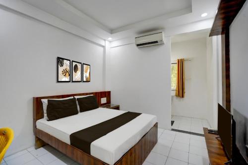 Un dormitorio con una cama y un televisor. en Collection O Warje Pune Formerly Choice Guest house, en Yerandwane
