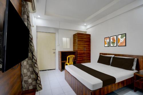 a hotel room with a bed and a television at Collection O Warje Pune Formerly Choice Guest house in Yerandwane